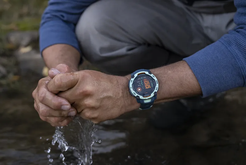 A person washes their hands in a river