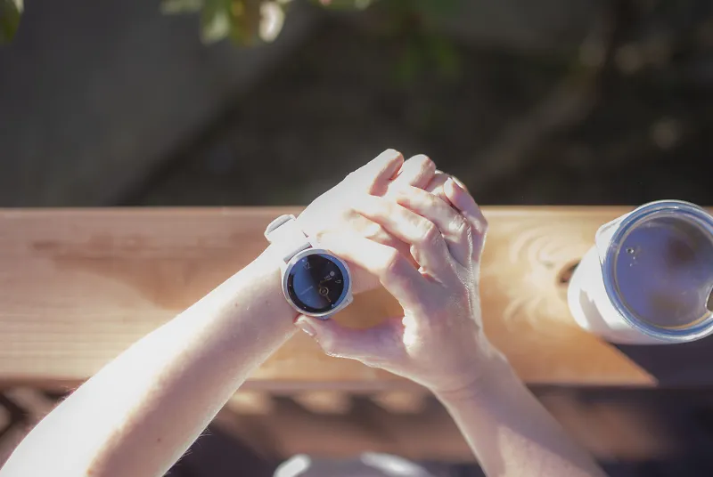 A person presses a button on a Garmin watch